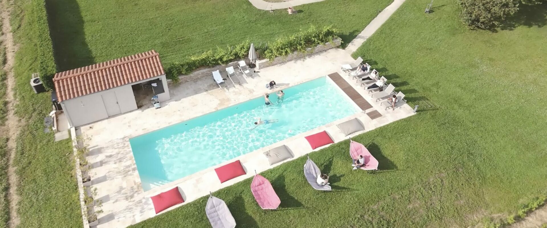 Vue aérienne de la piscine du Château de Condé, capturant un moment de détente lors du séminaire du GNCA, avec des participants profitant des installations et du cadre verdoyant.